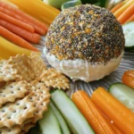 The Everything Bagel Cheese Ball is a fun snack. It blends rich cream cheese with sharp cheddar. This snack is easy to make and great for gatherings. You can prepare it in just 15 minutes. Then, chill it for an hour before serving. - 16 oz cream cheese, softened to room temperature - 1 cup shredded sharp cheddar cheese - 1/2 cup finely chopped green onions (scallions) - 1/2 cup finely chopped fresh dill - 2 tablespoons sour cream - 1 tablespoon garlic powder - 1 tablespoon onion powder - 2 teaspoons sea salt - 1/4 cup everything bagel seasoning - An assortment of fresh vegetables (such as carrots, cucumber, and bell peppers) and a variety of crackers for serving These ingredients blend to create a creamy, flavorful cheese ball. The cream cheese gives it a smooth base. The sharp cheddar adds a nice bite. Fresh herbs like green onions and dill add bright flavors. Everything bagel seasoning adds the perfect crunch. For the full recipe, check out the instructions that follow. Mixing Cream Cheese and Cheddar Start by placing 16 oz of softened cream cheese in a large bowl. Add 1 cup of shredded sharp cheddar cheese and 2 tablespoons of sour cream. Mix with a hand mixer or spatula until creamy and smooth. Make sure there are no lumps in the mixture. Incorporating Herbs and Seasonings Next, fold in 1/2 cup of finely chopped green onions and 1/2 cup of fresh dill. Add 1 tablespoon of garlic powder, 1 tablespoon of onion powder, and 2 teaspoons of sea salt. Stir gently to combine all the ingredients well. This step adds flavor and freshness to your cheese ball. Forming and Coating the Cheese Ball Once mixed, use your hands to shape the cheese into a ball. It doesn’t have to be perfect, so don’t stress! Roll the cheese ball in 1/4 cup of everything bagel seasoning. Make sure to coat all sides evenly. This gives your cheese ball a tasty crust. Wrap your cheese ball tightly in plastic wrap and place it in the refrigerator. Let it chill for at least 1 hour. This helps the cheese ball firm up, making it easier to serve and enjoy. When you're ready to serve, unwrap the cheese ball and place it on a nice platter. Surround it with fresh veggie sticks like carrots and cucumber, and add an assortment of crackers. This makes a great spreading station for your guests. For a festive touch, serve it on a rustic wooden board. This Everything Bagel Cheese Ball is simple, tasty, and perfect for any gathering. Enjoy every bite! For the full recipe, check out the instructions above. To make your cheese ball just right, focus on the cream cheese. Start with softened cream cheese. This helps it mix smoothly. Blend it well with the cheddar and sour cream. You want a creamy, lump-free texture. If it feels too soft, chill it for a bit. This makes forming the ball easier. The key to flavor lies in the everything bagel seasoning. Look for a mix that has sesame seeds, poppy seeds, garlic, and onion. A good blend will pack a punch. You can even make your own if you like! Just mix equal parts of each ingredient. Taste it before using. Adjust the amounts based on your preference. For a stunning display, think outside the box. Use a rustic wooden board to serve your cheese ball. Surround it with colorful veggie sticks like carrots, cucumbers, and bell peppers. Add a variety of crackers for texture. Make it look inviting! This setup not only looks great but also makes it easy for guests to grab a bite. Remember to check out the Full Recipe for all the details needed to create this tasty snack! {{image_4}} Adding Spicy Elements Want to spice things up? You can mix in some diced jalapeños or a dash of cayenne pepper. This will give your cheese ball a nice kick. Just add a little at a time to find your perfect heat level. You will love how the heat balances with the creamy cheese. Incorporating Dried Fruits or Nuts For a sweet twist, consider adding dried cranberries or chopped pecans. These ingredients bring a new texture and flavor. The nuts add crunch, while the fruits add a hint of sweetness. Stir them in gently, and enjoy this new layer of taste. Gluten-Free Options If you're serving guests with gluten sensitivities, use gluten-free crackers. You can find many tasty options in stores. Also, check your everything bagel seasoning to ensure it’s gluten-free. This way, everyone can enjoy the cheese ball without worry. Vegan Alternatives For a vegan version, swap the cream cheese with a plant-based alternative. Use vegan cheddar cheese too. You can also replace sour cream with cashew cream or silken tofu. These swaps keep the creamy texture while making it plant-based. Enjoy a delightful, guilt-free snack that everyone can share! Store any leftover cheese ball in an airtight container. This keeps it fresh and prevents drying. If you do not have a container, wrap it tightly in plastic wrap. Store it in the fridge. It will stay good for about a week. You can freeze the cheese ball for longer storage. First, wrap it tightly in plastic wrap. Then, place it in a freezer bag or container. It will last about two months in the freezer. When you want to use it, move it to the fridge for a night. Let it thaw slowly to keep the texture nice. To keep your cheese ball fresh, avoid leaving it out too long. When serving, only take out what you need. Keep the rest in the fridge. If you notice the cheese ball getting too soft, it’s best to eat it soon. Always check for any signs of spoilage before serving. Enjoy your Everything Bagel Cheese Ball as fresh as possible! You can serve the cheese ball with fresh veggies and crackers. I love using carrots, cucumbers, and bell peppers. They add crunch and color. Crackers in different shapes and sizes are also great. You can even use breadsticks for a fun twist. Guests can spread the cheese ball on these snacks. It makes a tasty combo! The cheese ball can stay fresh in the fridge for up to five days. Make sure to wrap it well in plastic wrap. This keeps it from drying out. If you see any changes in texture or smell, it’s best to toss it. Always trust your senses! Yes, you can make this cheese ball ahead of time! You can prepare it a day or two before your event. Just remember to chill it in the fridge to set. This way, when guests arrive, you can simply unwrap it and serve. It's a perfect time-saver for your gathering! For full preparation details, check the Full Recipe. This blog post covered making the perfect Everything Bagel Cheese Ball. We explored key ingredients, like cream cheese and fresh herbs. You learned step-by-step instructions for mixing and chilling. Tips helped enhance flavor and improve texture. Variations showed how to customize for different diets. Lastly, storage information kept your cheese ball fresh. Making this cheese ball is fun and rewarding. Enjoy your creation with friends or family!