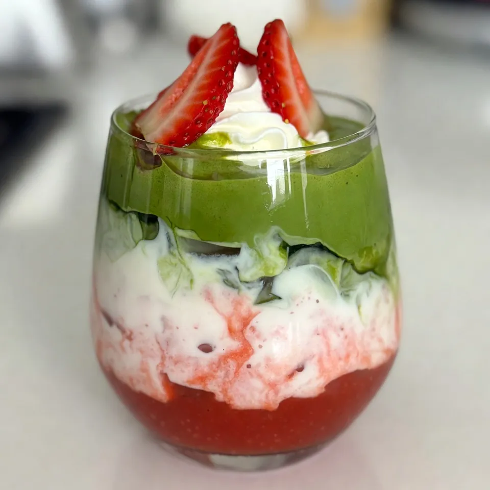 You need 1 cup of fresh strawberries. Make sure they are ripe and sweet. Hull and slice them before using. These strawberries bring bright flavor and a lovely color to your drink. For sweetness, use 2 teaspoons of honey or agave syrup. You can adjust this based on your taste. If you like it sweeter, add more. If you want it less sweet, use less. Sweeteners help balance the matcha's earthy notes. Use 1 teaspoon of matcha green tea powder. Matcha gives this latte a unique flavor and a boost of energy. Combine it with 1/2 cup of hot water (around 175°F/80°C) to dissolve it well. For milk, you can choose 1 cup of any type you like. Dairy, almond, oat, or coconut milk all work great. Each milk adds its own twist to the drink. {{ingredient_image_2}} To make the strawberry puree, grab a blender. Add 1 cup of fresh strawberries, hulled and sliced. Then, add 2 teaspoons of honey or agave syrup to sweeten. Blend until smooth and creamy. This step gives your latte a fresh and fruity base. Once done, transfer the puree to a bowl and set it aside. For the matcha, use 1 teaspoon of matcha green tea powder in a small mixing bowl. Pour in 1/2 cup of hot water, around 175°F. Use a whisk or milk frother to mix. Whisk vigorously until the matcha is fully dissolved and frothy. This step is key to a smooth drink with no lumps. Next, heat 1 cup of your chosen milk in a saucepan over medium heat. Stir occasionally to avoid boiling. You want the milk warmed, not scalded. If you like an iced latte, skip this step and use cold milk instead. If you want frothed milk, use a frother once the milk is warm. This creates a light and airy texture. To make your drink look stunning, follow these steps: - Layer the Puree First: Add the strawberry puree to the bottom of your glass. This gives a bright color and flavor base. - Pour Slowly: When adding the frothed milk, pour gently over the back of a spoon. This helps keep the layers separate. - Finish with Matcha: Carefully pour the whisked matcha over the milk. This creates a lovely green top layer. You can easily change the sweetness of your latte: - Use Honey or Agave: Start with two teaspoons of honey or agave. Blend it with the strawberries. - Taste and Test: After blending, taste the puree. If you want it sweeter, add a little more honey or syrup. - Natural Sweeteners: Try maple syrup or coconut sugar for a different flavor. This recipe is flexible for various diets: - Dairy-Free Options: Choose almond, oat, or coconut milk instead of dairy milk. - Sugar-Free Choices: Use a sugar substitute like stevia if you want to cut out sugar. - Low-Carb Alternatives: Swap out honey for a low-carb sweetener. This keeps the flavor without extra carbs. Enjoy experimenting with these tips and tricks to make your Strawberry Matcha Latte the best it can be! Pro Tips Fresh Strawberries are Key: Always choose ripe, fresh strawberries for the best flavor in your puree. The sweetness and juiciness of fresh strawberries will elevate your matcha latte. Water Temperature Matters: Ensure the water for whisking matcha is around 175°F/80°C. Using boiling water can make the matcha taste bitter, affecting the overall flavor of your latte. Froth for Texture: Frothing the milk adds a delightful creaminess and makes the latte more enjoyable. If you don’t have a frother, you can shake the milk in a jar or whisk it vigorously. Layering Technique: When pouring the milk and matcha, do it slowly and gently to maintain the layers. This not only looks beautiful but also enhances the drinking experience. {{image_4}} To make an iced strawberry matcha latte, follow these simple steps. First, prepare the strawberry puree as you normally would. Then, instead of heating the milk, use cold milk right from the fridge. Add ice cubes to your tall glass before layering. Spoon in the strawberry puree, pour the cold milk, and finally, pour the whisked matcha on top. This gives you a refreshingly cool drink perfect for hot days. If you want a dairy-free option, choose any plant-based milk. Almond, oat, or coconut milk works well. They add unique flavors that blend nicely with the strawberries and matcha. For a creamier texture, try using full-fat coconut milk. This gives your latte a rich and smooth taste, making it just as delicious as the original. You can enhance your strawberry matcha latte with extra flavors. For a sweet touch, add a splash of vanilla extract. It complements the strawberries and matcha nicely. Another option is to mix in some coconut milk. This adds a tropical flair to your drink. Feel free to experiment with other flavors. A hint of cinnamon or a drop of almond extract can make your latte unique and delightful. If you have leftover strawberry puree, store it in an airtight container. Keep it in the fridge and it will stay fresh for about three days. You can also freeze it for up to three months. Just pour the puree into ice cube trays and freeze. Once solid, pop the cubes into a freezer bag. This way, you can easily add strawberry flavor to future drinks or desserts. To keep your matcha green tea powder fresh, store it in a cool, dark place. Use an airtight container to protect it from light and moisture. This helps maintain its vibrant color and flavor. If you buy matcha in bulk, consider dividing it into smaller containers. This keeps the opened container fresh longer. Enjoy your strawberry matcha latte right after making it. The layers look best when fresh. If you have leftovers, store them in the fridge without ice. The milk can separate, but a good stir will help. Consume it within a day for the best taste. If you want to enjoy it later, reheat it gently on the stove. Avoid boiling to keep the flavors intact. Matcha is packed with nutrients. It gives you a boost of energy without a crash. This green tea has antioxidants that help fight free radicals. It may also improve focus and calmness. Drinking matcha can help with weight loss too. It can speed up your metabolism. Plus, it supports heart health by lowering cholesterol levels. Yes, you can use frozen strawberries! They work well in this recipe. Just blend them straight from the freezer. This will give you a cold drink, perfect for hot days. You might need to add a little more sweetener, though. Frozen strawberries can taste less sweet than fresh ones. Making this latte vegan is easy. Substitute regular milk with plant-based milk. Almond, oat, or coconut milk are great choices. Instead of honey, use agave syrup or maple syrup for sweetness. With these swaps, you keep the taste and enjoy a vegan treat. This article covered how to make a Strawberry Matcha Latte. We explored fresh strawberries, sweeteners, and milk choices. You learned how to prepare the puree, whisk matcha, and froth milk. The tips offered help you achieve a perfect layered drink. You also saw variations, like iced options and dairy-free swaps. We discussed how to store leftovers for freshness. Remember, with each step, you can create a delicious and healthy drink. Enjoy your crafting journey!