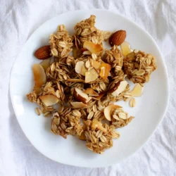 To make Coconut Almond Granola Clusters, you need: - 2 cups rolled oats - 1 cup unsweetened shredded coconut - 1 cup chopped almonds - 1/2 cup almond butter - 1/3 cup honey or maple syrup - 1/4 cup melted coconut oil - 1/2 teaspoon pure vanilla extract - 1/2 teaspoon sea salt - 1/2 teaspoon ground cinnamon You can add your favorite dried fruits for extra flavor. Try: - 1/3 cup dried cranberries - Other dried fruits like raisins or apricots Let&rsquo;s break down the nutrition of these key ingredients: - Rolled oats: Great source of fiber and energy. They help keep you full. - Unsweetened shredded coconut: Adds healthy fats and a nice flavor. - Chopped almonds: Packed with protein, fiber, and vitamin E. They support heart health. - Almond butter: Provides healthy fats and protein, making it a creamy delight. - Honey or maple syrup: Natural sweeteners that add flavor and energy. - Melted coconut oil: Contains medium-chain triglycerides for quick energy. - Vanilla extract: Enhances flavor and adds a comforting aroma. - Sea salt: Balances sweetness and brings out the flavors. - Ground cinnamon: Offers antioxidants and a warm spice taste. Each ingredient plays a role in making these clusters not just tasty but also nutritious. {{ingredient_image_2}} First, heat the oven to 325&deg;F (165&deg;C). This helps the granola bake evenly. Line a baking sheet with parchment paper. This step makes cleanup easy and prevents sticking. In a big bowl, add 2 cups of rolled oats, 1 cup of shredded coconut, and 1 cup of chopped almonds. Sprinkle in 1/2 teaspoon of sea salt and 1/2 teaspoon of ground cinnamon. Mix well so all the dry ingredients blend together. In a separate bowl, combine 1/2 cup of almond butter, 1/3 cup of honey or maple syrup, and 1/4 cup of melted coconut oil. Add 1/2 teaspoon of pure vanilla extract. Whisk until smooth. This mixture binds the granola. Pour the wet mixture over the dry ingredients. Stir gently to coat everything well. Then, use your hands to grab small amounts and squeeze them into clusters. Place these clusters on the baking sheet, leaving space between each one. Put the baking sheet in the oven. Bake for 20-25 minutes. Halfway through, stir the mixture for even browning. The granola should become a nice golden brown when it&rsquo;s ready. After baking, take the sheet out of the oven. Let the granola cool completely on the sheet. It will harden as it cools. Once cooled, break larger clusters if you like smaller bites. Store them in an airtight container at room temperature for up to two weeks. Enjoy your delicious coconut almond granola clusters! To make great clusters, you need to squeeze the mix tightly. When you form the clusters, use your hands to pack them. Aim for about 2-3 tablespoons of the mixture per cluster. This helps them stick together when baking. If the clusters are too loose, they may fall apart. Even baking is key for good granola. Spread the clusters on the baking sheet with some space in between. This allows hot air to flow around them. Stir the mixture halfway through baking. This helps them brown evenly and prevents burning. Keep an eye on them as they bake. They should be golden brown when ready. You can change the flavor with fun add-ins. Try different nuts like walnuts or pecans. Seeds like chia or flaxseed add health benefits too. Dried fruits, like cranberries or apricots, give sweetness. For a spice kick, add nutmeg or ginger. Mix and match to find your favorite combo! Pro Tips Use Fresh Ingredients: Always opt for fresh almonds and coconut for the best flavor and crunch in your granola clusters. Adjust Sweetness: Feel free to modify the amount of honey or maple syrup based on your preferred sweetness level. Experiment with Add-Ins: Try adding other nuts or seeds, such as walnuts or sunflower seeds, for additional texture and nutrition. Store Properly: Ensure that your granola clusters are completely cooled before storing them to maintain their crunchiness. {{image_4}} You can switch up the nuts in your clusters. Try using walnuts, pecans, or hazelnuts. Each nut brings its unique flavor and crunch. For seeds, consider pumpkin or sunflower seeds. These add extra nutrition and a nice texture to your granola. If you want a different flavor, explore sweeteners. You can use agave syrup, brown sugar, or even coconut sugar. Each sweetener will change the taste a bit. Maple syrup adds a rich flavor, while honey gives a floral note. Experiment to find what you like best. Spices can enhance your granola. Try adding nutmeg, ginger, or cardamom for warmth. For a health boost, include chia seeds or flaxseeds. These superfoods increase fiber and nutrients. You can also mix in cacao nibs for a chocolatey twist. To keep your coconut almond granola clusters fresh, store them in an airtight container. This prevents air from making them stale. You can keep them at room temperature. Avoid direct sunlight or heat sources that may affect their quality. If you want, you can also refrigerate them for longer freshness. Check for signs that your granola clusters are no longer good. If they smell off or have a strange texture, it&rsquo;s time to toss them. Staleness can also show up if they lose their crunch. If the clusters feel soft or soggy, they are past their prime. When stored properly, your granola clusters can last up to two weeks. After that, they may lose their flavor and crunch. If you refrigerate them, they can last a bit longer, up to a month. Just remember to check for freshness before enjoying them! Yes, you can! If you want to skip the nuts, use seeds instead. Pumpkin seeds or sunflower seeds work great. They add crunch and nutrition. You can also use extra oats or coconut to fill the space. You can use peanut butter, cashew butter, or sunflower seed butter. Each option gives a different flavor. Choose one that suits your taste. Just make sure it is smooth for easy mixing. Absolutely! You can try agave syrup, brown rice syrup, or coconut nectar. Each sweetener will change the flavor a bit. Pick one that you enjoy, and adjust the amount to your taste. To make these clusters gluten-free, use certified gluten-free oats. Regular oats often contain gluten. Check labels to ensure they are safe. All other ingredients in this recipe are naturally gluten-free. Yes, these granola clusters are healthy! They are rich in fiber, healthy fats, and protein. The oats provide energy, while the coconut adds flavor and nutrition. Enjoy them as a snack or breakfast boost. If your granola clusters get stale, bake them again! Spread them out on a baking sheet. Bake at 300&deg;F (150&deg;C) for about 10 minutes. Keep an eye on them to avoid burning. This will help restore their crunch. Now you know how to make tasty coconut almond granola clusters. I covered key ingredients, step-by-step instructions, and tips for the best results. You can mix flavors and customize the recipe to fit your taste. Remember to store your granola properly to keep it fresh. With these tips, you can bake healthy snacks that everyone will love. Enjoy your tasty creations and feel proud of your homemade granola!