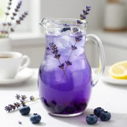 - 1 cup fresh blueberries - 1 cup freshly squeezed lemon juice - 1 tablespoon dried culinary lavender - 1 cup water (for lavender infusion) - 4 cups cold water (for dilution) - 3/4 cup honey or agave syrup - Ice cubes - Extra blueberries and lavender for garnish To create a delightful Blueberry Lavender Lemonade, you need fresh ingredients. Start with ripe blueberries. These berries add a sweet and tangy flavor. They also give your drink a lovely color. Ensure you pick fresh blueberries for the best taste. Next, grab some lemons. You will need enough to get one cup of juice. Freshly squeezed lemon juice tastes much better than store-bought. The bright flavor of the lemons balances the sweetness of the honey or agave syrup. You will also need dried culinary lavender. It gives your lemonade a unique floral note. Choose high-quality lavender to ensure a strong flavor. The aroma will fill your kitchen as you prepare this drink. For the additional ingredients, you will need water for the lavender infusion. Boil one cup of water and steep the lavender to extract its essence. This step is crucial for a fragrant drink. You will also mix in four cups of cold water to dilute your lemonade. This makes it refreshing and perfect for summer. Adjust the amount of honey or agave syrup based on your taste. You can always add more if you like it sweeter. Don&rsquo;t forget the ice cubes! They keep your drink cool and refreshing. For a beautiful touch, garnish with extra blueberries and lavender sprigs. This makes the drink look as good as it tastes! {{ingredient_image_2}} - Start by boiling 1 cup of water in a small pot. - Once it boils, take it off the heat. - Add 1 tablespoon of dried culinary lavender to the hot water. - Cover the pot and let it steep for 15 minutes. - After steeping, strain the mixture through a fine sieve into a bowl. - Discard the lavender flowers and let the infusion cool to room temperature. - While the lavender steeps, rinse 1 cup of fresh blueberries under cold water. - Place the rinsed blueberries in a blender. - Blend until smooth and creamy. - If you want a silkier drink, strain the puree through a fine mesh sieve. - Press down with a spatula to get every bit of juice. - In a large pitcher, mix the cooled lavender infusion and 1 cup of freshly squeezed lemon juice. - Add 3/4 cup of honey or agave syrup to the mix. - Pour in the blueberry puree. - Stir well until everything blends together nicely. - Gradually add 4 cups of cold water to the pitcher. - Taste the mixture and adjust the flavors. - Add more honey for sweetness or lemon juice for tartness if needed. - Cover the pitcher and chill in the fridge for at least 1 hour before serving. To make your blueberry lavender lemonade just right, you can customize the sweetness. Honey or agave syrup works well. Start with 3/4 cup and taste it. If you want it sweeter, add more. Balancing tartness is key too. Use fresh lemon juice for the best flavor. If it tastes too sour, add a little more honey. You want a nice blend of sweet and tangy. Your choice of glassware can make this drink more fun. Use tall glasses for a refreshing look. Try mason jars for a rustic feel. For ice cubes, consider using frozen blueberries instead. They keep your drink cold and add extra flavor. You could also freeze lemonade in ice cube trays for a fun twist. Garnishing your drink boosts aroma and looks great. Add fresh blueberries on top and a sprig of lavender. This adds color and a fragrant touch. Flavored ice cubes can also elevate your drink. Freeze blueberry puree or lemon juice in ice trays. As they melt, they add flavor without watering down your drink. Pro Tips Use Fresh Ingredients: For the best flavor, opt for fresh blueberries and freshly squeezed lemon juice. Fresh ingredients will elevate the taste of your lemonade. Adjust Sweetness: Taste your lemonade after mixing and adjust the sweetness according to your preference. Some may prefer a sweeter drink, while others might enjoy a more tart flavor. Chill for Flavor: Allow the lemonade to chill for at least an hour before serving. This resting time helps the flavors meld together for a more harmonious taste. Garnishing Tips: For an elegant presentation, garnish each glass with additional fresh blueberries and a sprig of lavender. This not only looks great but also enhances the aroma. {{image_4}} You can make Blueberry Lavender Lemonade even more fun by adding other fruits. Strawberries or raspberries work great in this drink. Simply blend them in with the blueberries for extra flavor. You can also mix in citrus fruits like oranges or limes. This will give your drink a nice burst of zestiness and brightness. If you want to turn this refreshing drink into a cocktail, there are many options. Try adding vodka or gin for a light twist. These spirits pair well with the flavors of blueberry and lavender. You can even use champagne for a bubbly treat. Just pour it over the lemonade for a special touch. For a sugar-free drink, use alternative sweeteners like stevia or monk fruit. These will keep your lemonade sweet without the calories. You can also try using fresh fruit to add sweetness. Mash some extra blueberries into the mix for flavor. This way, you maintain the taste without sugar. Store leftover blueberry lavender lemonade in an airtight container. This helps keep the flavors fresh. It will stay good for up to five days in the fridge. Always give it a quick stir before serving again. You can freeze blueberry lavender lemonade to enjoy later. Pour it into ice cube trays for easy use. Once frozen, transfer the cubes into a freezer bag. For serving, thaw the cubes in the fridge overnight. You can also blend them with fresh water for a slushy treat. Blueberry Lavender Lemonade is a refreshing drink. It combines sweet blueberries, fragrant lavender, and tangy lemon. The blueberries give it a rich color and natural sweetness. Lavender adds a floral note that makes it unique. Each sip offers a balance of sweet and tart flavors. You will love how it cools you down on a hot day. Yes, you can make this lemonade ahead of time. Prepare it a few hours or even a day in advance. Just remember to chill it well in the fridge. This allows the flavors to mix and deepen. If you store it too long, the taste may change. So, try to enjoy it within a few days for the best flavor. This drink has several health benefits. Blueberries are packed with vitamins and antioxidants. They help support your heart and brain. Lavender can aid in relaxation and better sleep. Lemons offer vitamin C, which boosts your immune system. This lemonade is a tasty way to enjoy these healthy ingredients. You can use dried blueberries, but they will change the texture. Dried blueberries are sweeter and less juicy. To use them, soak them in warm water first to soften. After soaking, blend them just like fresh blueberries. This will help you get a smooth lemonade. This blueberry lavender lemonade offers a fresh twist on a classic drink. You learned how to create a delightful flavor using simple ingredients like blueberries, lemon juice, and lavender. I shared tips for adjusting sweetness and serving in fun ways. Whether you serve it chilled, transformed into a cocktail, or store it for later, this drink fits every occasion. Enjoy experimenting with flavors and share this refreshing beverage with friends and family. Trust me, they will love it!
